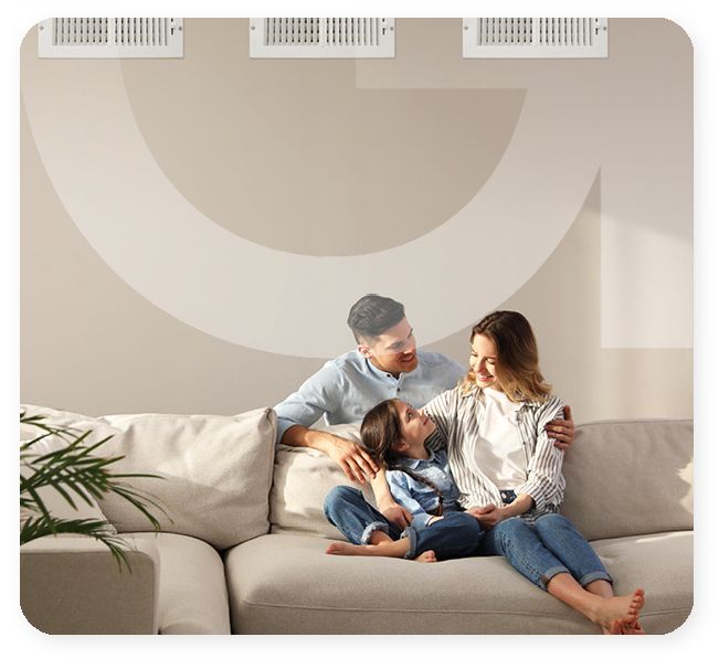 Happy family relaxing on sofa in bright living room with clean indoor air and fresh ventilation.